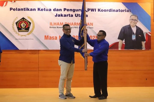 Sekretaris PWI Jaya, Kesit B Handoyo (kiri) menyerahkan bendera pataka kepada Ketua Koordinatoriat PWI Jakarta Utara, Ilham Dharmawan (kanan) di kantor Wali Kota Jakarta Utara, Selasa (21/3/2023).