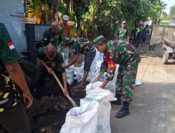 Babinsa dan Warga Bersihkan Jalan Pasca Banjir di Desa Sukorejo