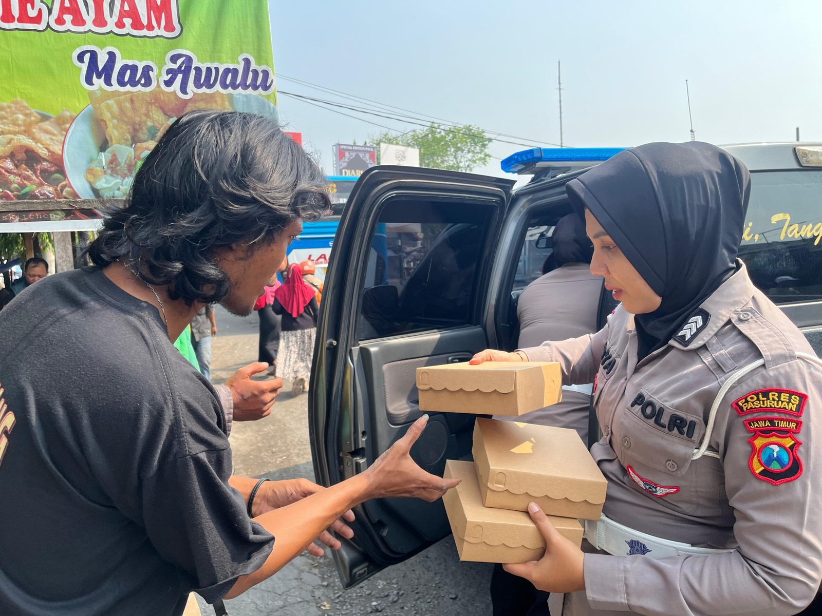pembagian puluhan nasi kotak kepada para tukang becak, ojek online (ojol), dan masyarakat sekitar yang melintas di wilayah Kota Pasuruan.