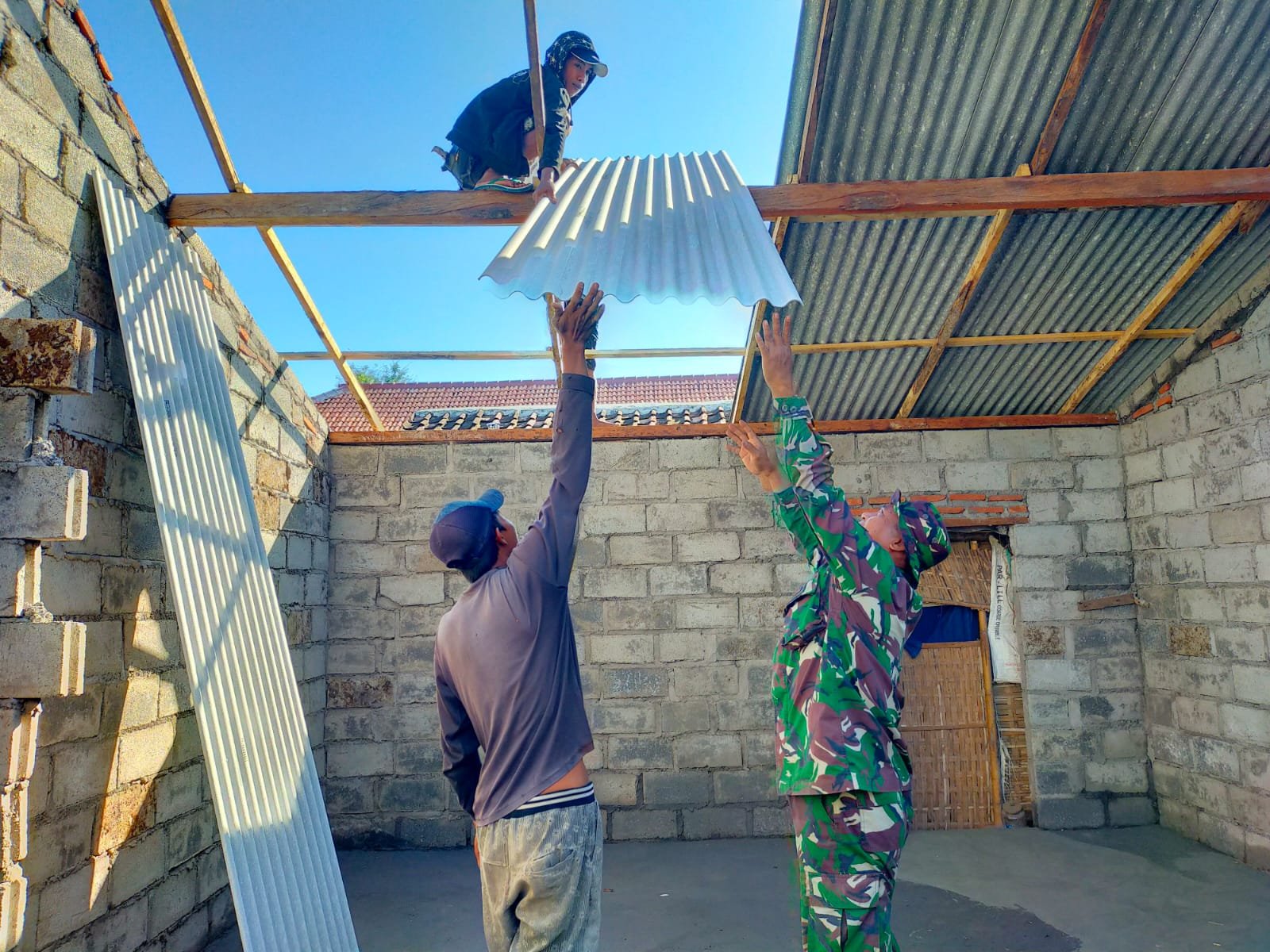 Koramil 0820/10 Kuripan membantu memperbaiki atap rumah milik Mulyadi warga RT 05 RW 02 Dusun Gunungsari, Desa Resongo, Kecamatan Kuripan, Kabupaten Probolinggo.