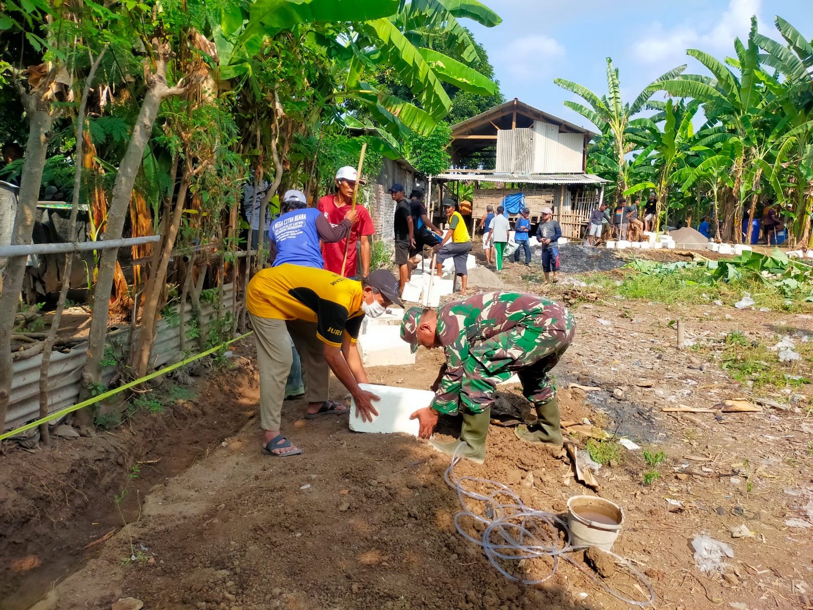 Sertu Muchlas dari Koramil 0819/20 Gempol, turut serta dalam kegiatan kerja bakti pemasangan pagar pembatas di area Tempat Pemakaman Umum (TPU),