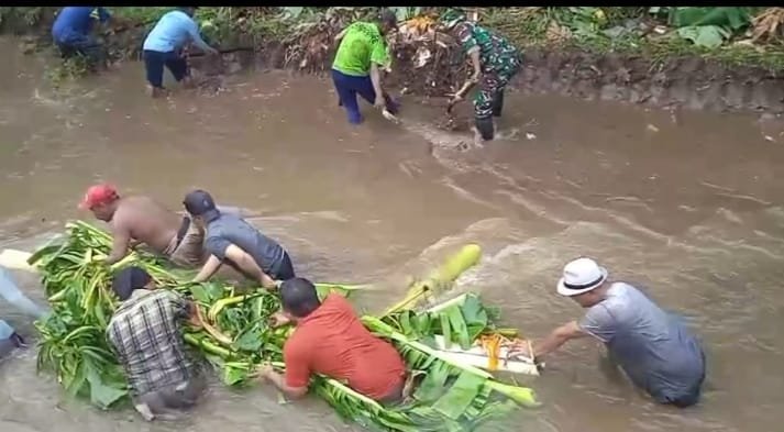 Koramil 0820-22/Dringu bersama perangkat desa dan masyarakat melaksanakan kerja bakti normalisasi bantaran sungai di Dusun Wonopaten