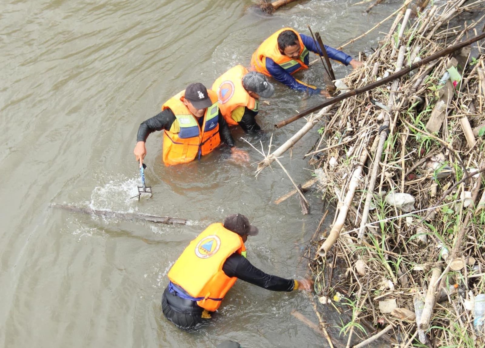 membersihkan tumpukan sampah dibawah jembatan lama.