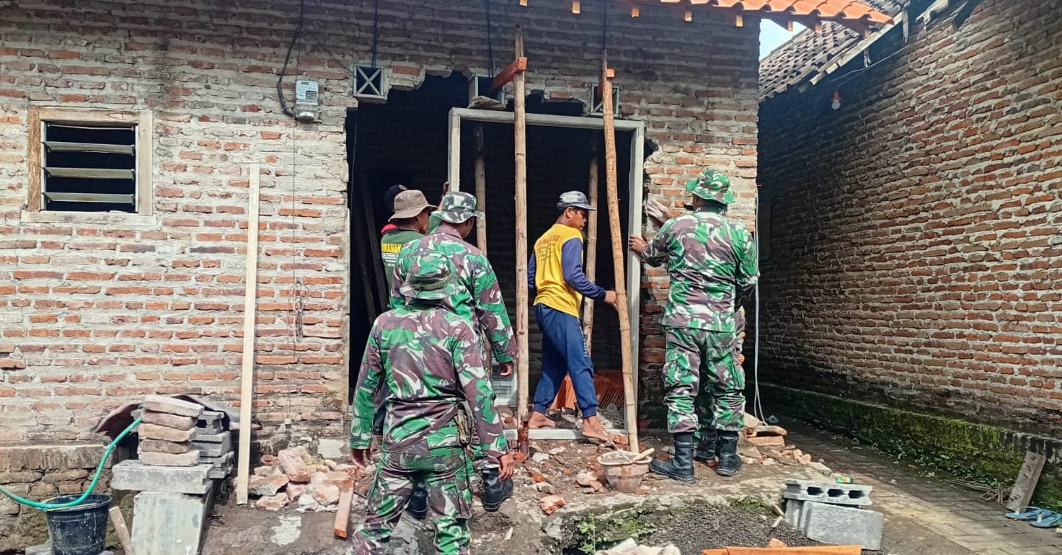 anggota Satgas TMMD Ke-127 Kodim 0819/Pasuruan tampak telaten memasang kusen