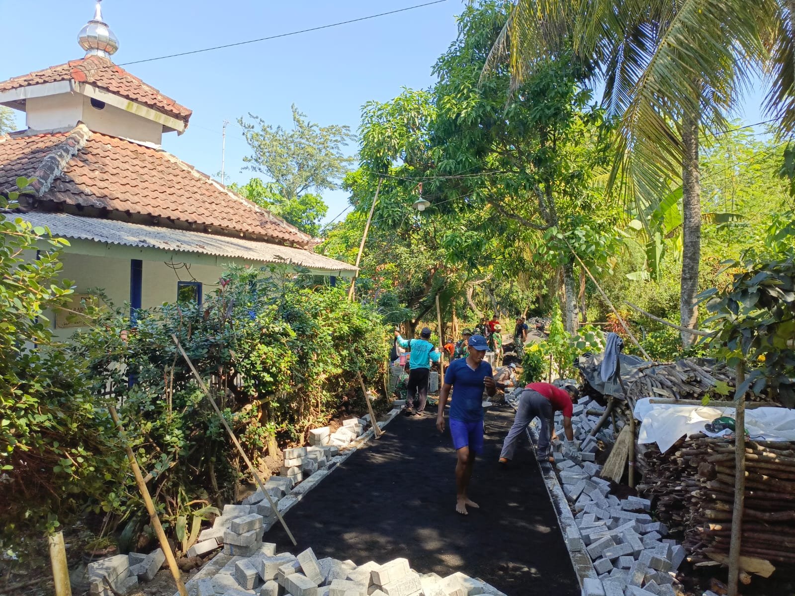 Satgas TMMD Ke-128 Kodim 0820 Probolinggo bersama warga terus mempercepat pavingisasi jalan di Dusun Klagin, Desa Brabe, Kecamatan Maron. (Foto: ist).