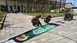 Satgas TMMD Ke-128 Kodim 0820 Probolinggo bersama anggota Koramil 0820-21/Maron dan warga bergotong royong membersihkan lokasi serta memasang umbul-umbul di Desa Brabe, Kecamatan Maron. (Ist/sp)