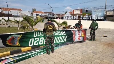 Satgas TMMD Ke-128 Kodim 0820 Probolinggo bersama personel Koramil 0820-21/Maron dan warga Desa Brabe bergotong royong membersihkan lingkungan serta memasang umbul-umbul untuk menyambut kunjungan Tim Wasev Sterad TNI AD. (Ist/sp)