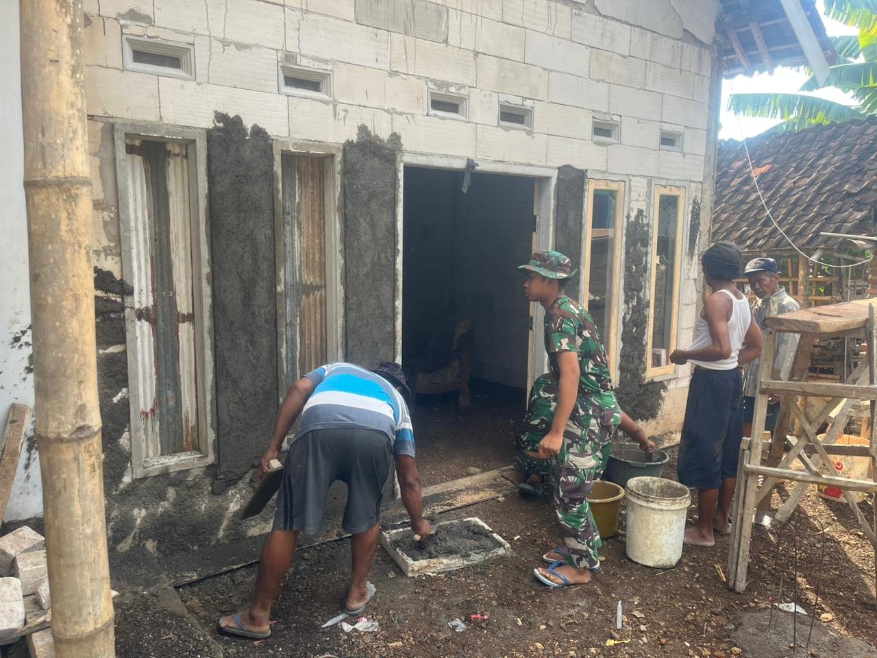 Satgas TMMD Ke-128 Kodim 0820 Probolinggo mulai melakukan plester dinding rumah milik Khosinah (70) di Dusun Klagin, Desa Brabe, Kecamatan Maron. (Ist/sp)