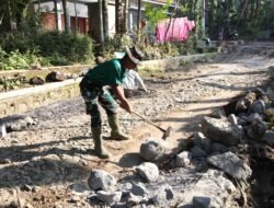 Satgas TMMD ke-129 Kodim 0821/Lumajang Maksimalkan Pembuatan Parit, Prada Muhamad Fathur Pecah Batu untuk Perkuat Drainase
