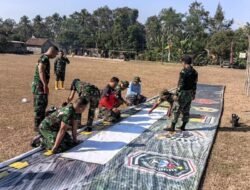 Jelang Penutupan TMMD ke-129 Lumajang, Peltu Hariadi Pasang Banner di Lapangan Ledok Tempuro